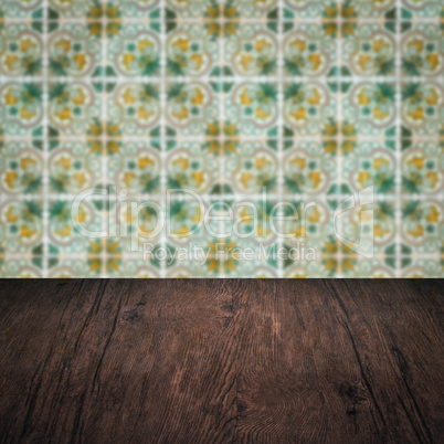 Wood table top and blur vintage ceramic tile pattern wall