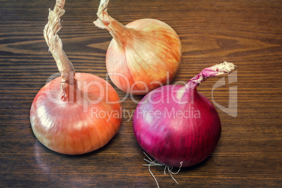 Still life: three large onions on the table.