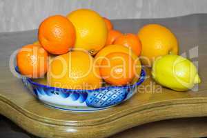 Oranges and tangerines in a beautiful ceramic vase.