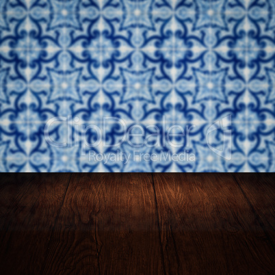 Wood table top and blur vintage ceramic tile pattern wall