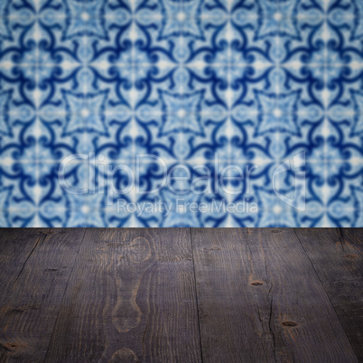 Wood table top and blur vintage ceramic tile pattern wall