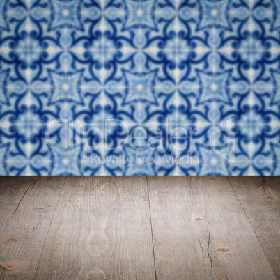 Wood table top and blur vintage ceramic tile pattern wall