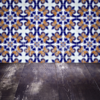 Wood table top and blur vintage ceramic tile pattern wall Wood table top and blur vintage ceramic tile pattern wall