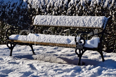 Neuschnee auf Parkbank