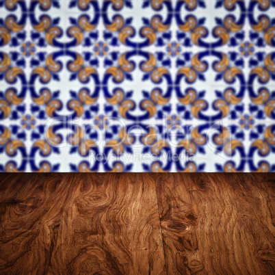 Wood table top and blur vintage ceramic tile pattern wall