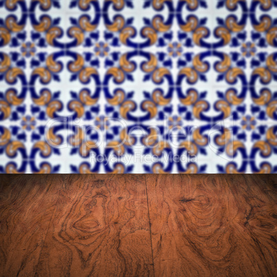 Wood table top and blur vintage ceramic tile pattern wall Wood table top and blur vintage ceramic tile pattern wall