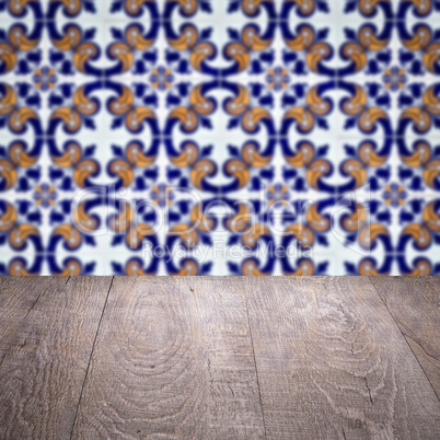 Wood table top and blur vintage ceramic tile pattern wall