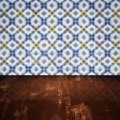 Wood table top and blur vintage ceramic tile pattern wall