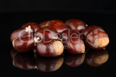 Chestnuts on a black reflective background