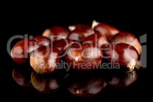 Chestnuts on a black reflective background