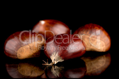 Chestnuts on a black reflective background