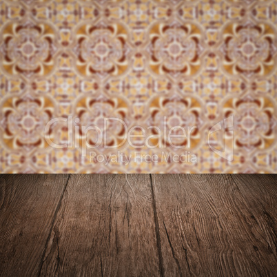 Wood table top and blur vintage ceramic tile pattern wall