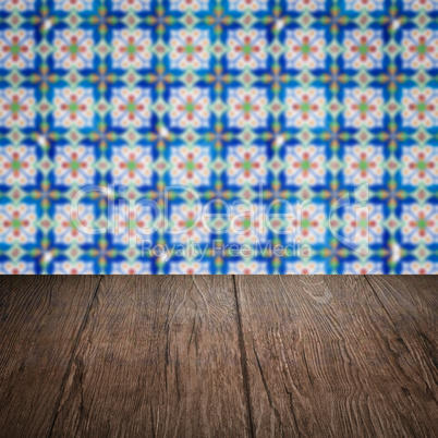 Wood table top and blur vintage ceramic tile pattern wall