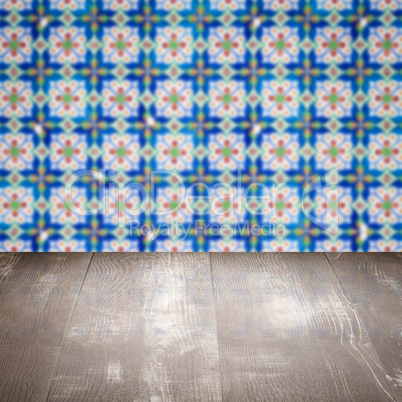 Wood table top and blur vintage ceramic tile pattern wall Wood table top and blur vintage ceramic tile pattern wall