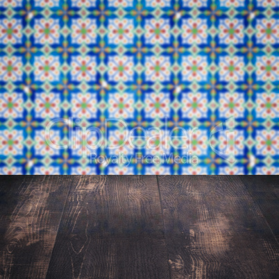 Wood table top and blur vintage ceramic tile pattern wall