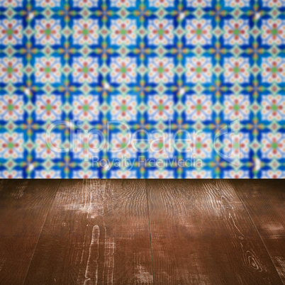 Wood table top and blur vintage ceramic tile pattern wall