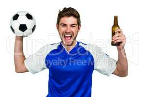 Portrait of excited man holding football and beer bottle