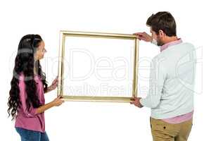 Smiling couple holding picture frame