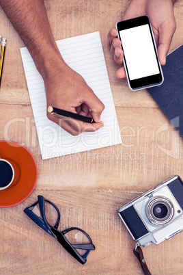 High angle view of businessman hand holding smart phone while wr