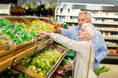 Smiling senior couple buying apples