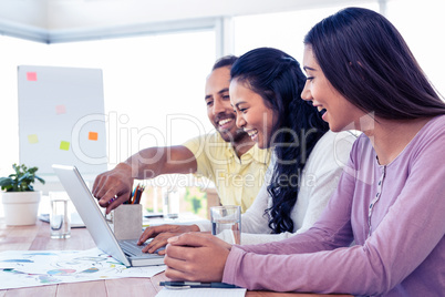 Cherrful business team working over laptop