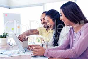 Cherrful business team working over laptop