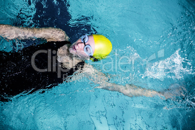 Fit female swimmer doing the back stroke