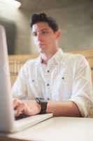 Concentrated male student using laptop