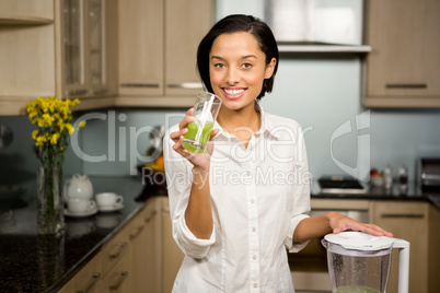 Smiling brunette holding glass of smoothie