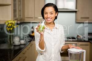 Smiling brunette holding glass of smoothie