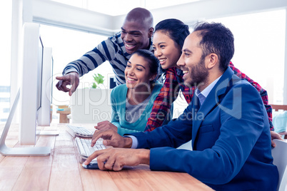 Cheerful business people looking at computer screen