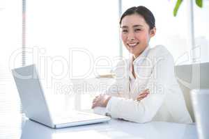 Smiling businesswoman with arms crossed