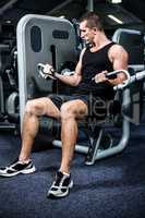 Serious muscular man using exercise machine