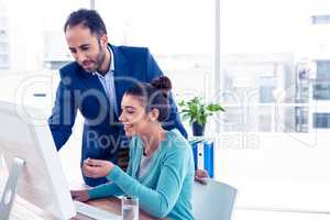 Happy businessman and businesswoman working on computer