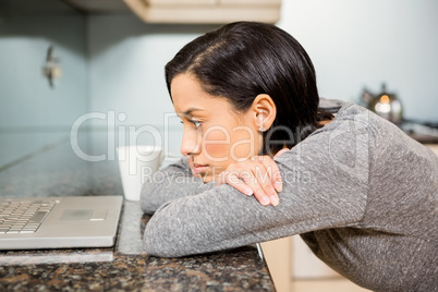 Upset brunette looking at laptop