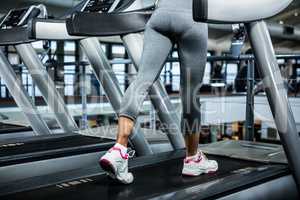 Mid section of woman using treadmill