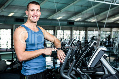 Smiling muscular man using stopwatch