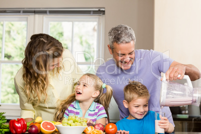 Happy family preparing healthy smoothie