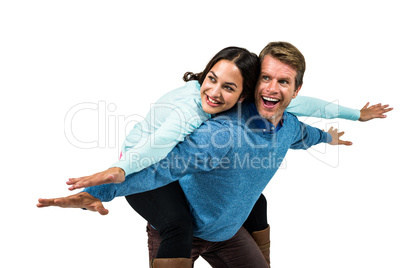 Cheerful couple wearing warm clothing with arms outstretched
