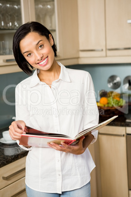 Smiling brunette reading book