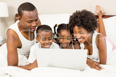 Happy family lying on the bed