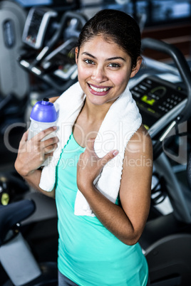 Smiling fit woman with towel and water