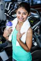 Smiling fit woman with towel and water