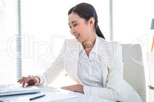 Smiling businesswoman typing on her laptop