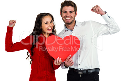 Cheerful couple holding paper heart