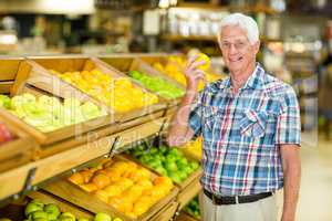 Smiling senior man holding orange