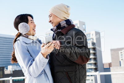 Couple laughing while holding smartphone