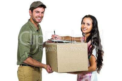 Woman signing for pack delivery with smiling postman