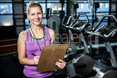 Smiling trainer holding clipboard