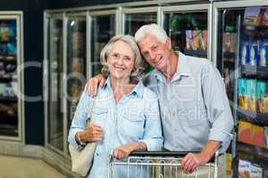 Smiling senior couple with cart